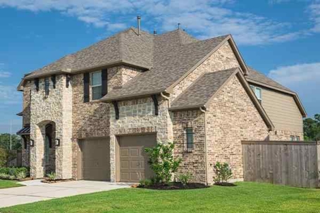 Large tan brick home with a large lawn.